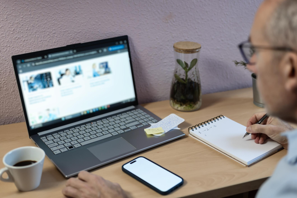 Person tar notater under nettbasert teori og eksamenstrening på laptop